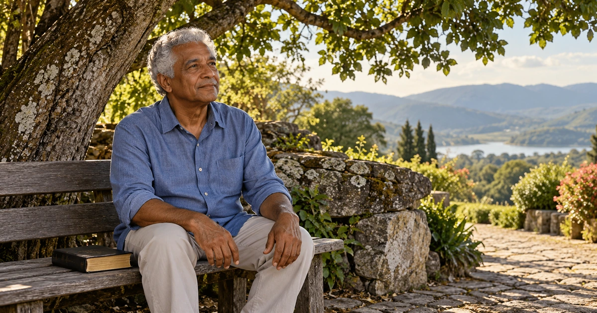 Um homem idoso descansa em um banco sob uma árvore, com uma Bíblia ao lado e pedras na paisagem do jardim.