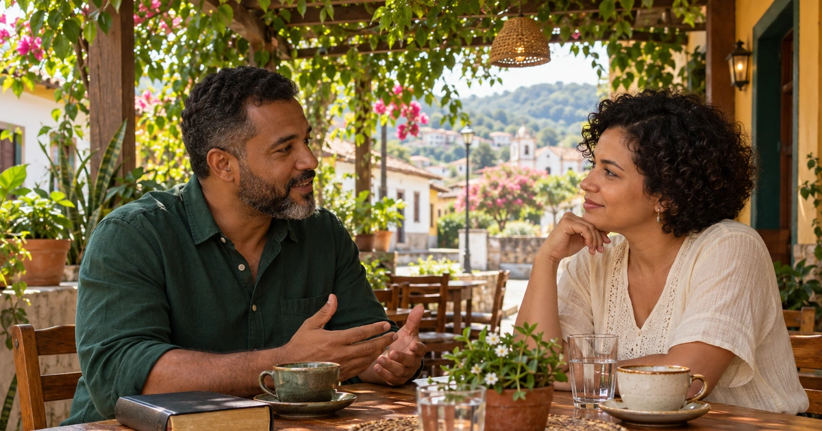 Um homem e uma mulher conversam com atenção em uma varanda, com uma Bíblia fechada e xícaras sobre a mesa.